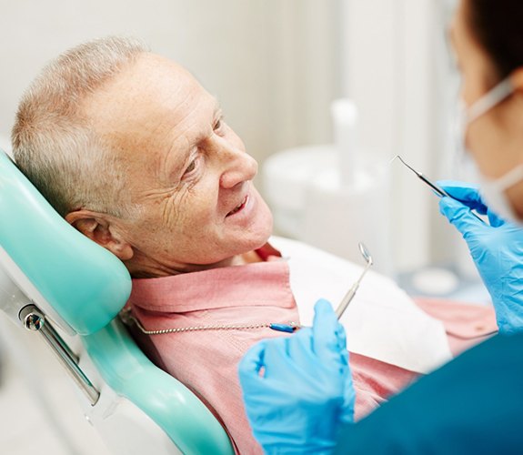 Older man smiling at dentist during an appointment