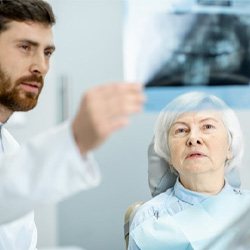 Woman looking at X-ray at dentist’s office  