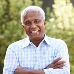 Man outdoors smiling with dentures   