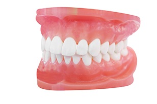 Older woman smiling while wearing dentures