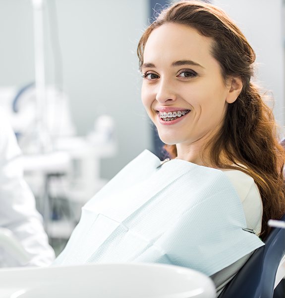 Woman with braces smiling during checkup