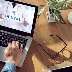 Using laptop computer to look up information about dental insurance