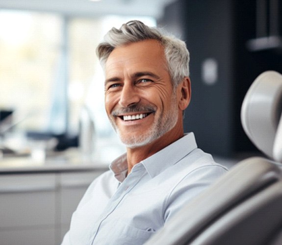 Man smiling after undergoing treatment for failed implant