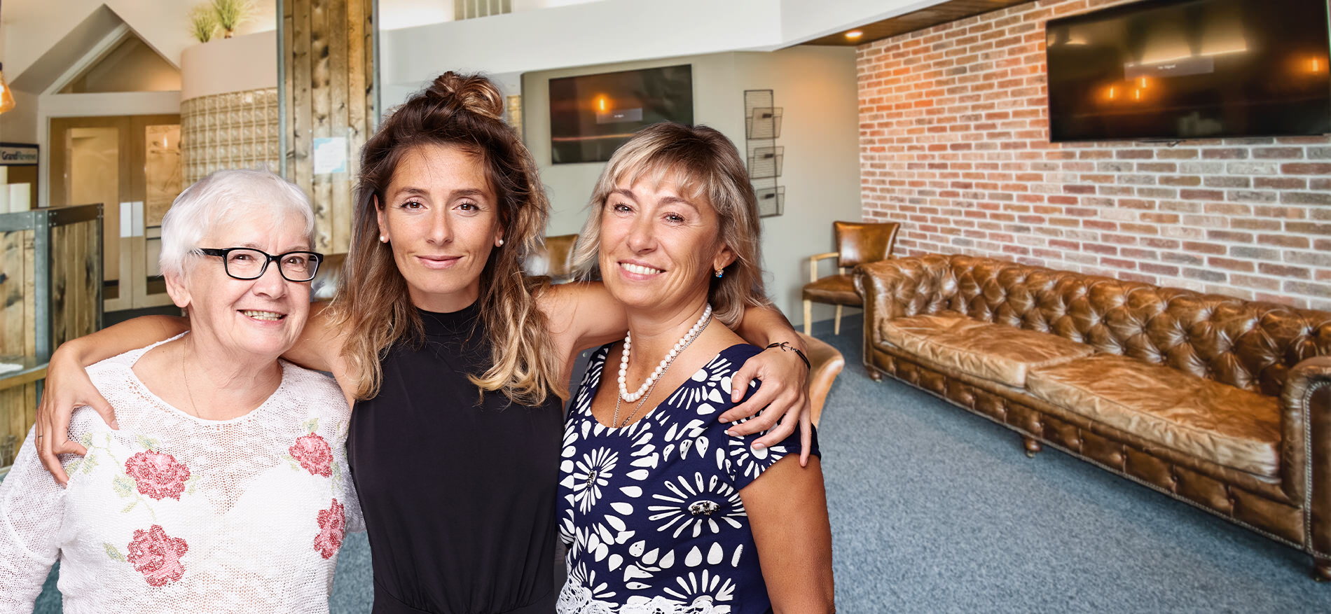 Three smiling women in dental office waiting room