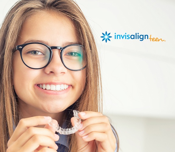 Young woman placing an Invisalign Teen aligner tray