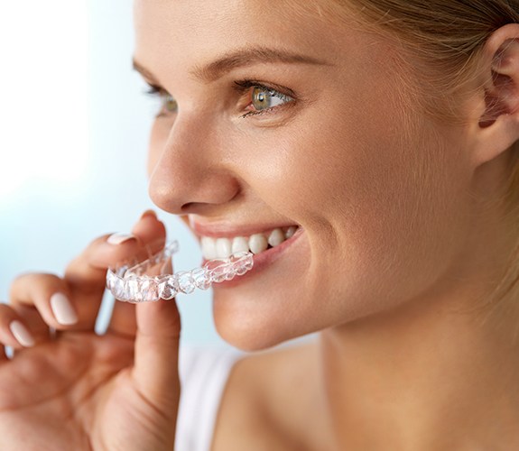 Woman placing her Invisalign tray