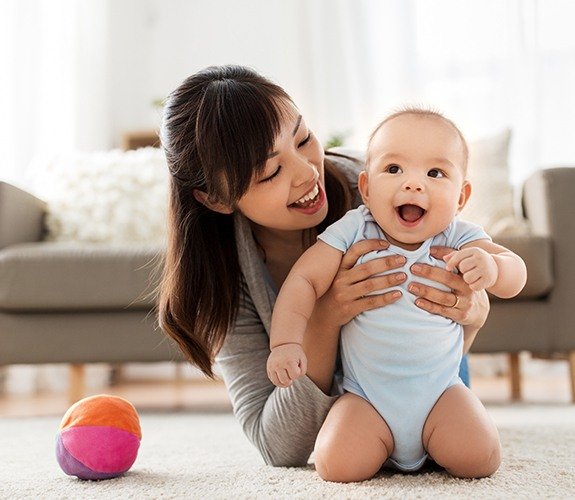 Dentist checking baby's smile after frenectomy for lip and tongue tie