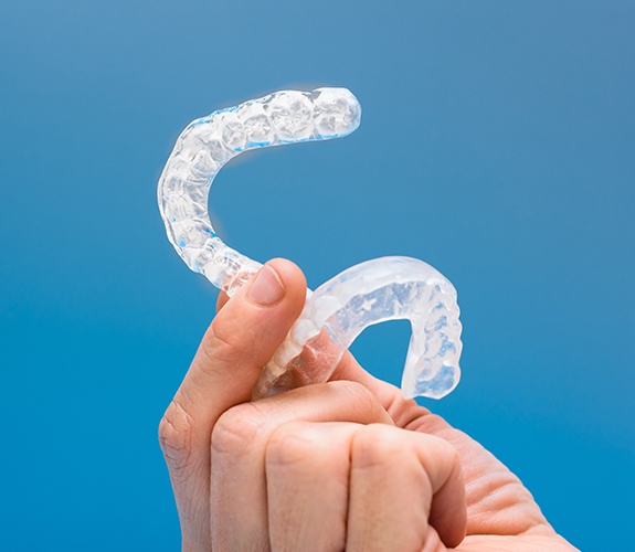Hand holding set of clear nightguards