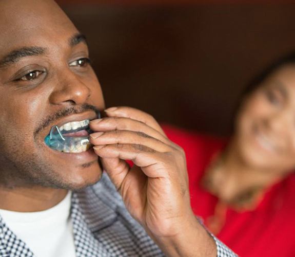 Man placing a custom sleep apnea appliance