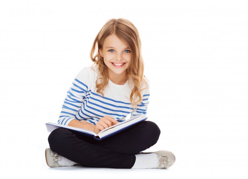 young girl studying and smiling