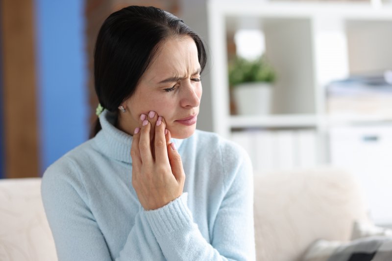 a woman experiencing dental implant pain
