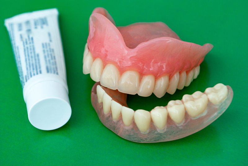 set of dentures and denture adhesive
