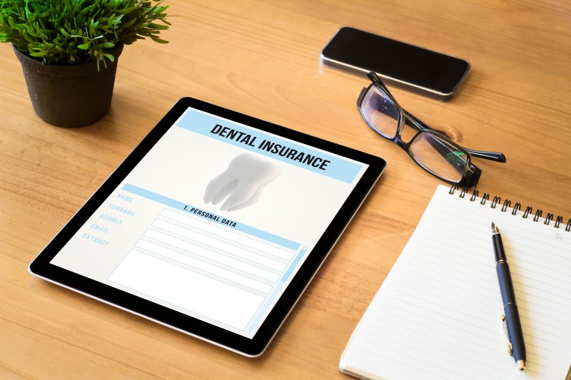 dental insurance paperwork on tablet and glasses